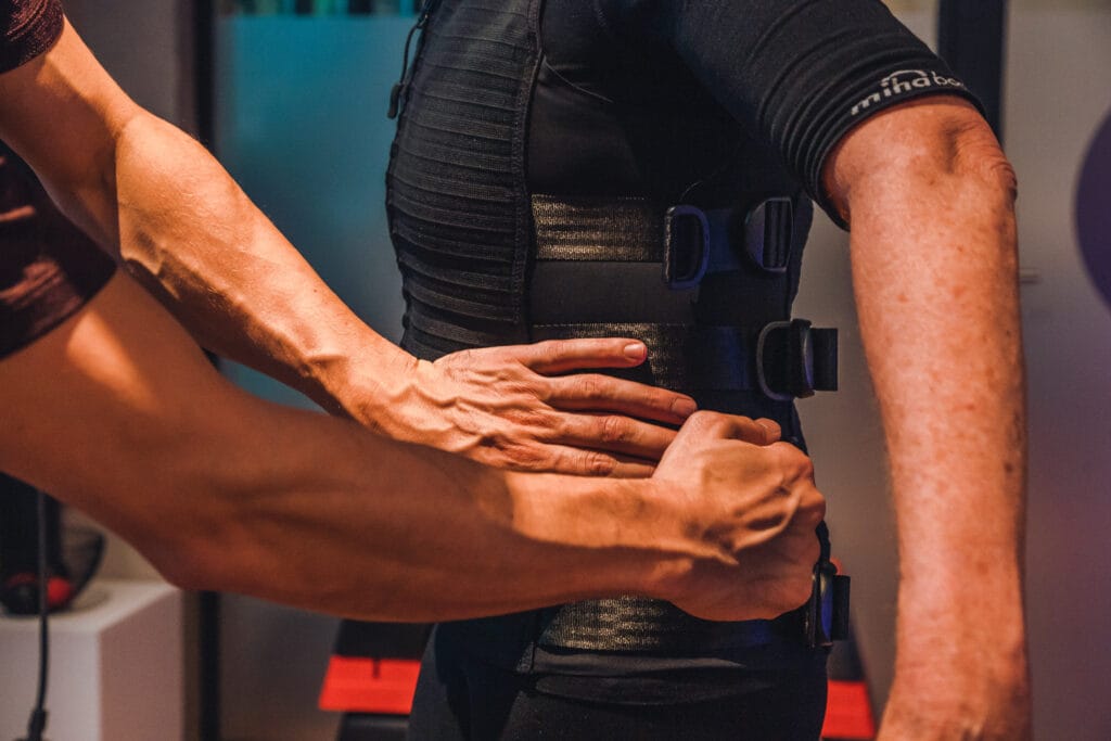 Het aantrekken van de EMS bodysuit tijdens een EMS training